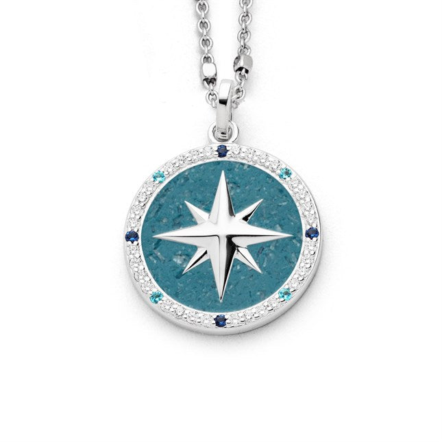 Anhänger "Kompassrose 2.0" aus rhodiniertem 925er Sterling-Silber, mit 40 Zirkoniasteinen in Weiß, Hellblau und Dunkelblau und blauem Steinsand (Kyanit) im Inneren.